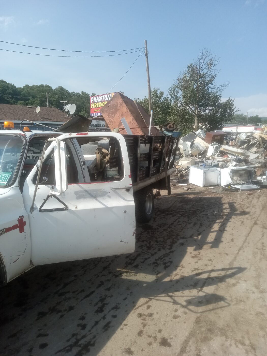 Flatbed truck loaded with appliance scrap parked roadside