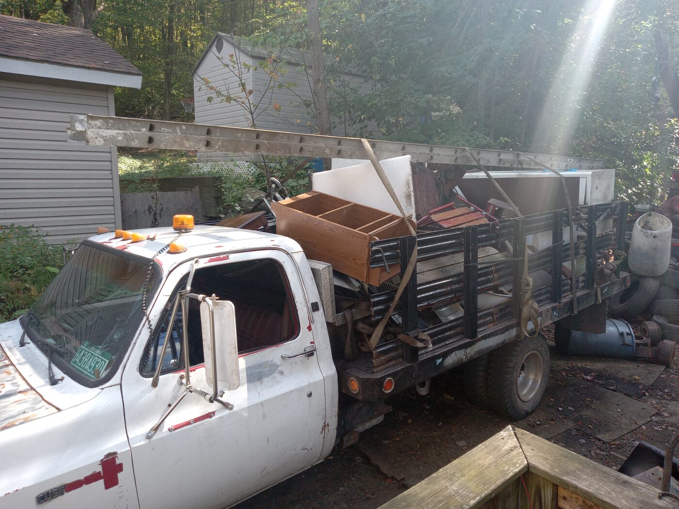 Flatbed truck loaded with furniture and cabinets strapped down