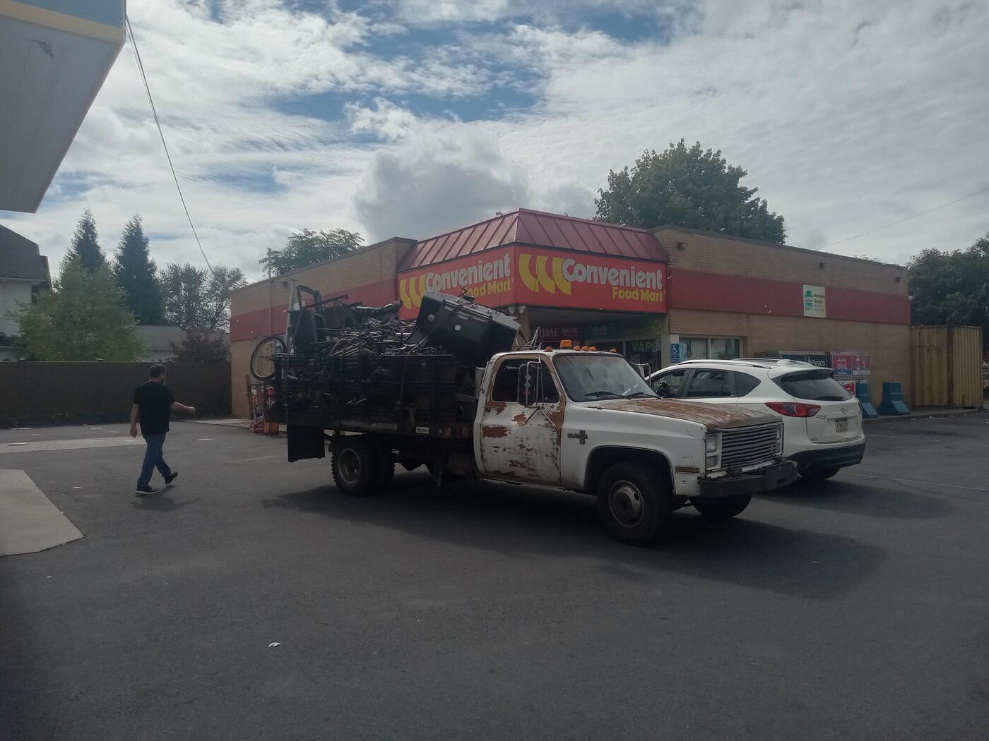 Loaded scrap truck parked at a gas station convenience store