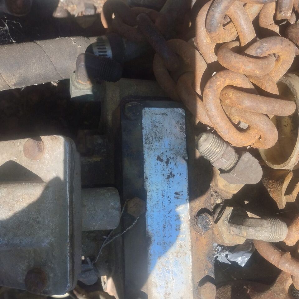 Rusty chain, bolts, and salvaged hardware sorted at the BuccaneerSalvage yard