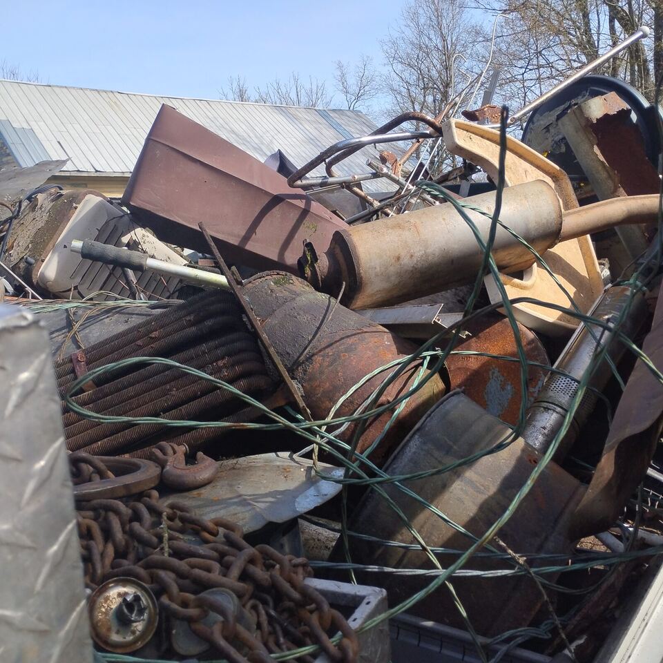 Trailer piled high with rusty scrap metal, chain, and pipe from a free local haul